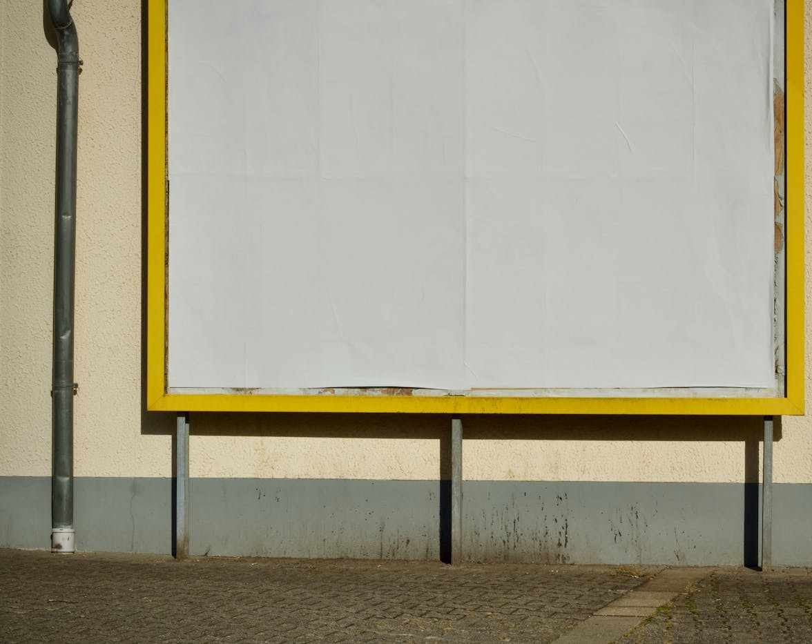 Blank outdoor billboard panel on a sunny urban wall